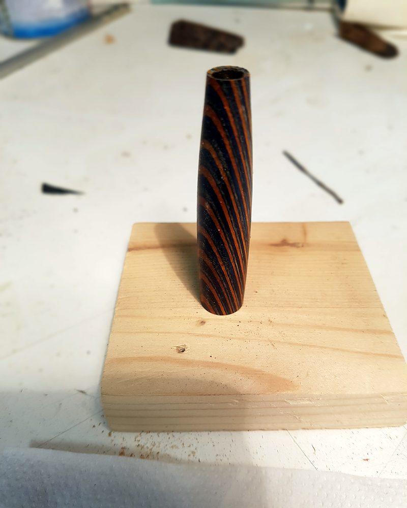 Un fusto in laminato appena rifinito, in piedi su un supporto ad asciugare